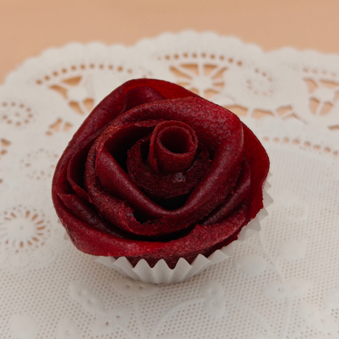 Close-up of a single edible pastila rose made from dried fruit on a lace doily