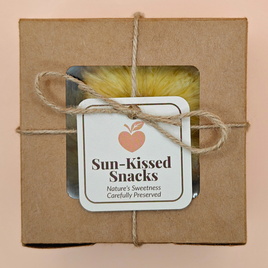 Packaged slow-dried pineapple chips in a kraft gift box tied with twine and branded “Sun-Kissed Snacks
