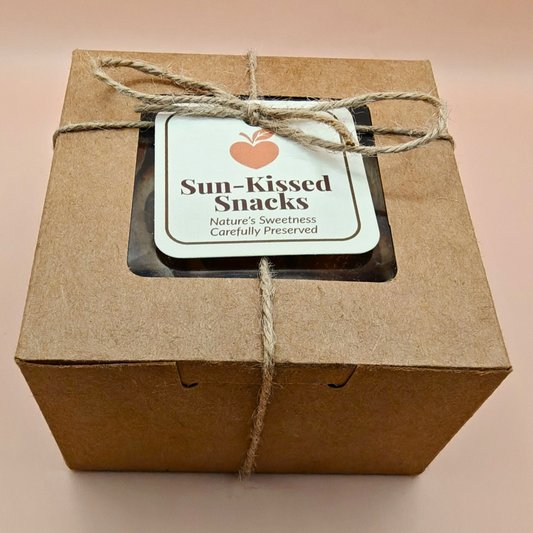 Packaged slow-dried mandarin chips in a kraft gift box tied with twine and branded “Sun-Kissed Snacks” label
