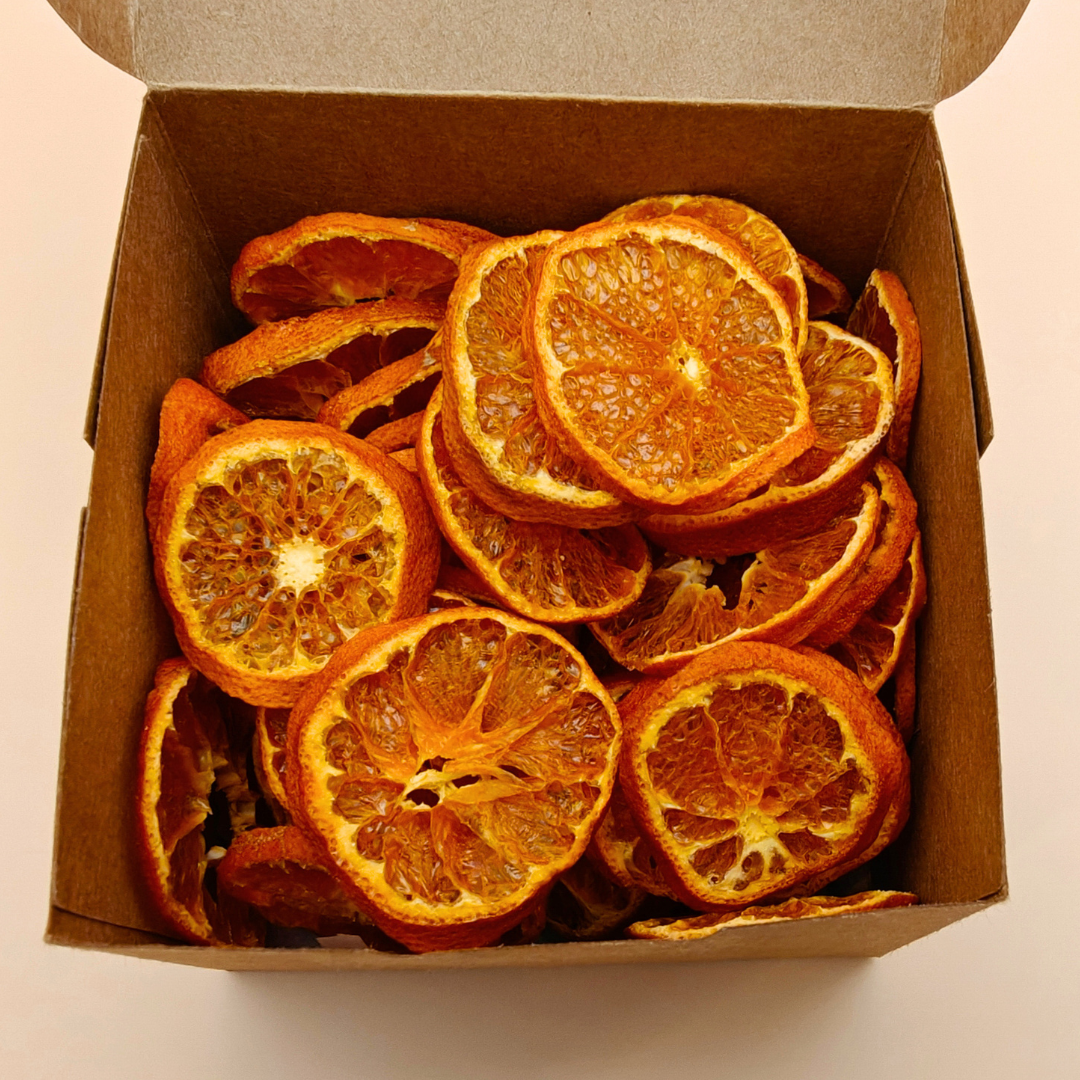 Open kraft box revealing richly colored slow-dried mandarin chips inside, ready to snack or gift