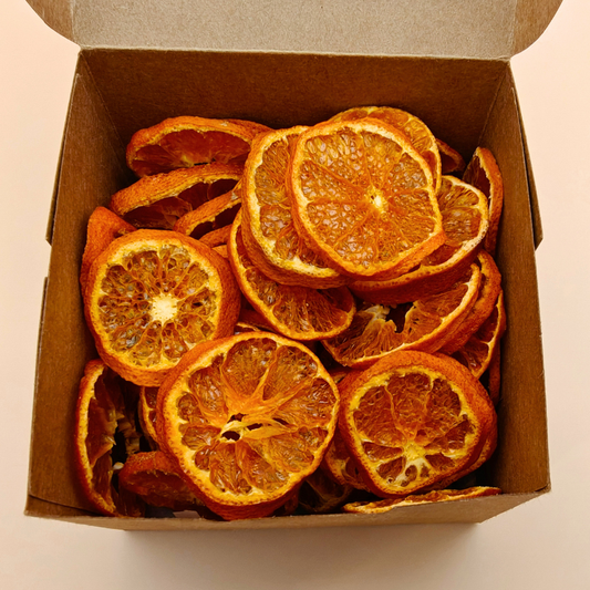 Open kraft box revealing richly colored slow-dried mandarin chips inside, ready to snack or gift