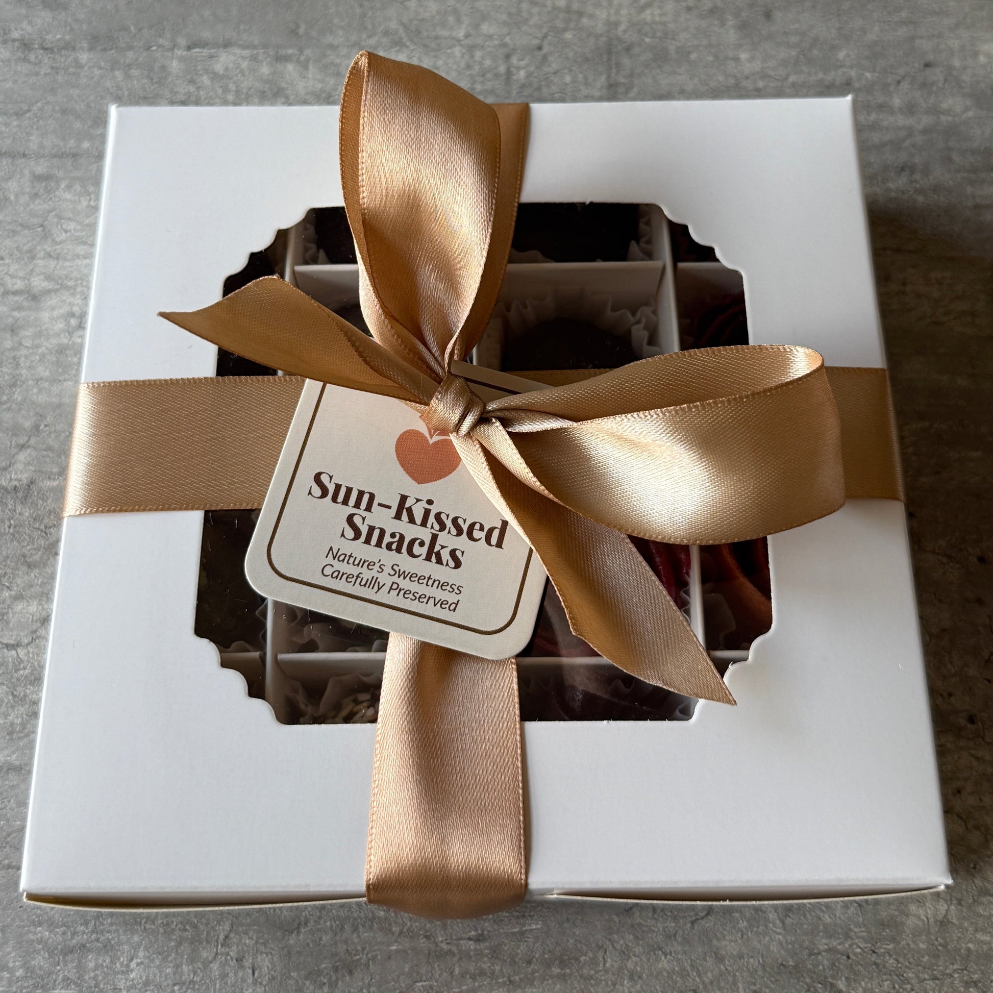 white box with cream bow and Sun-Kissed Snacks Tag